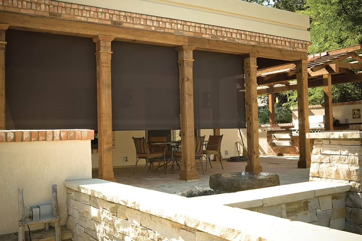 Oasis® 2700 Patio Sun Shades half-drawn over a wood and stone outdoor seating area.
